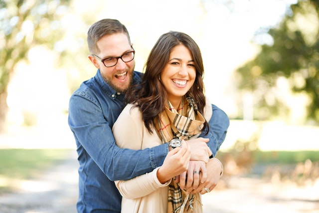 couple with arms wrapped around each other smiling