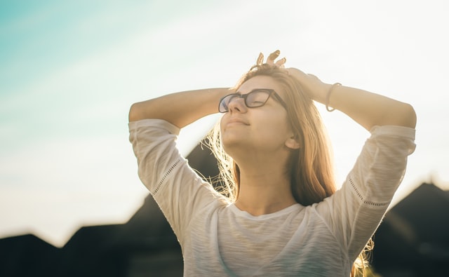 photo of a woman looking up at the sky smiling