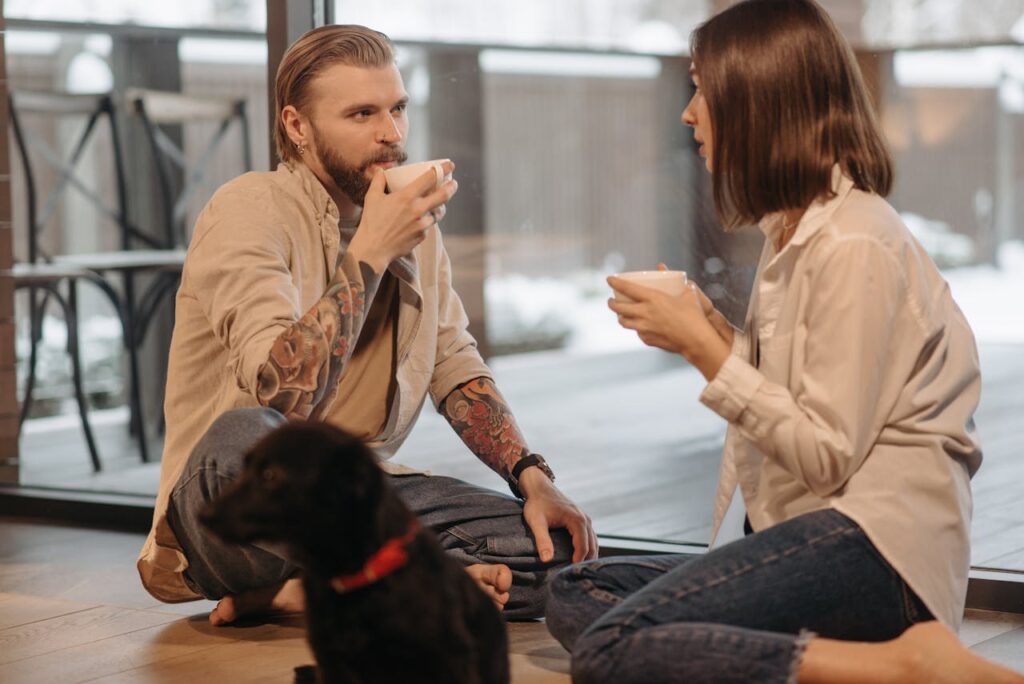 couple-drinking-coffee-sitting-beside-a-dog